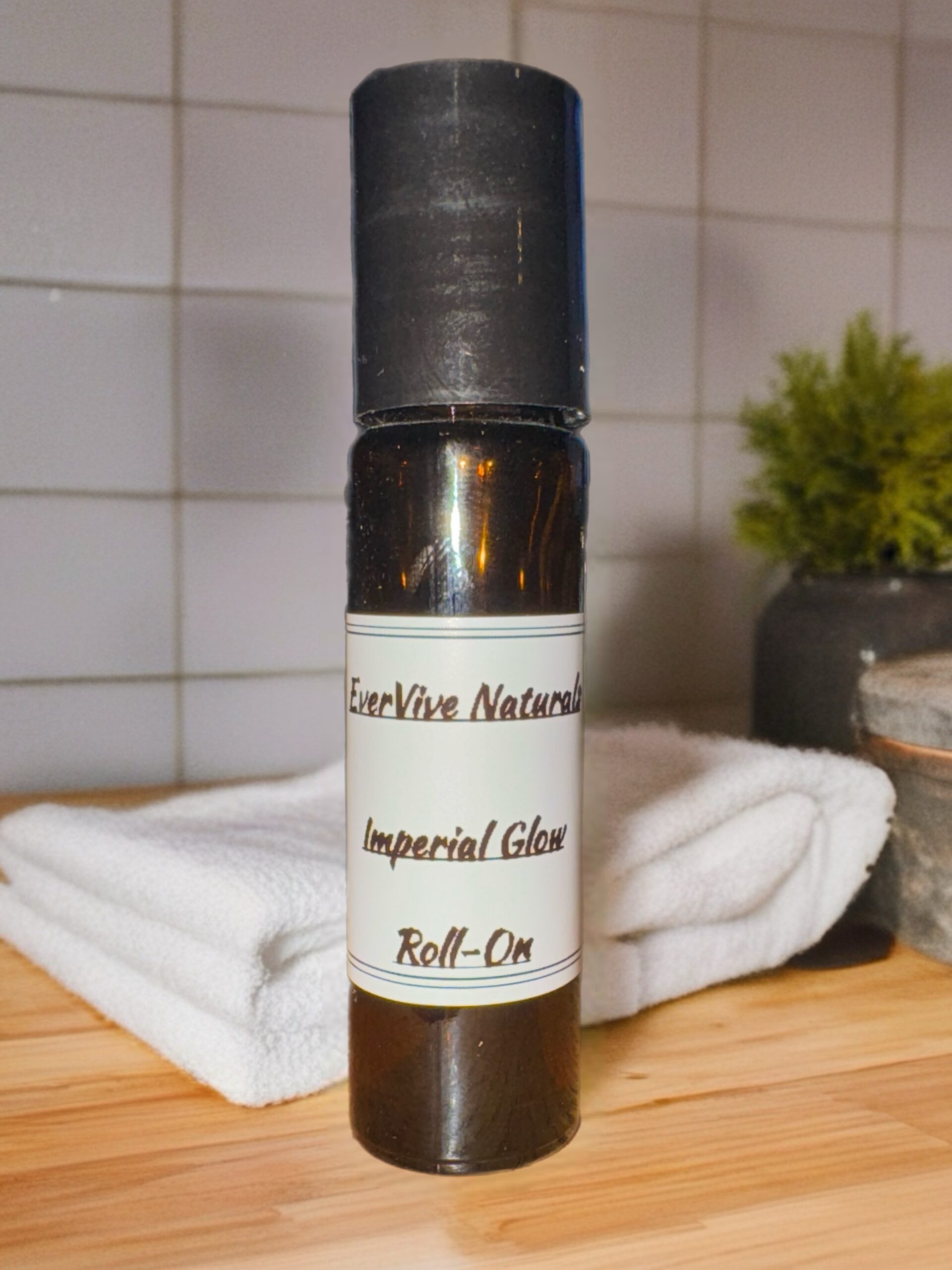 Imperial Glow Roll-On – essential oil roll-on with lavender, palmarosa, and almond oil on marble tray with dried petals and silk cloth