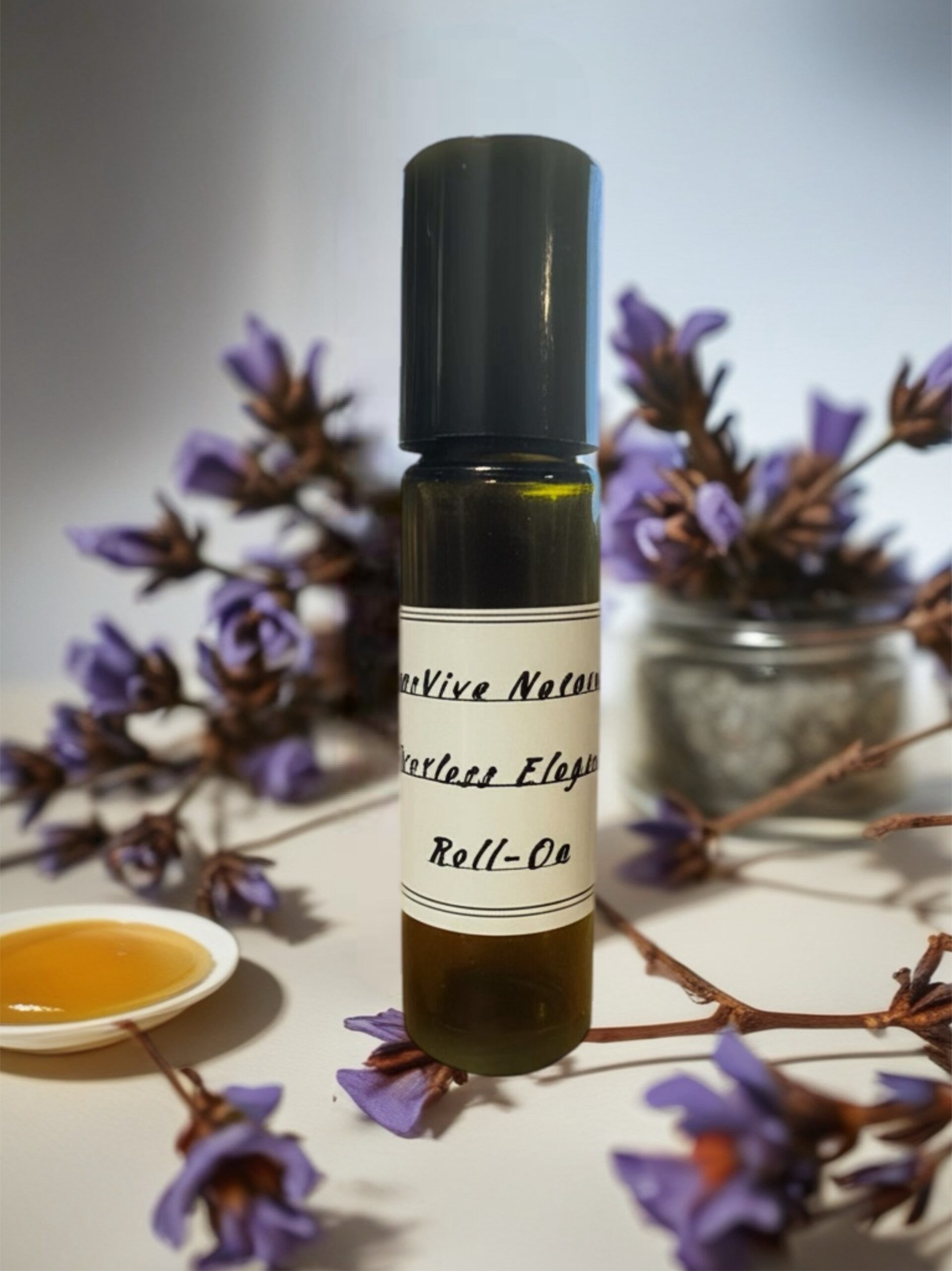 Effortless Elegance Roll-On – anti-aging essential oil roll-on with frankincense and jojoba on vanity tray with silk scarf and gold accents