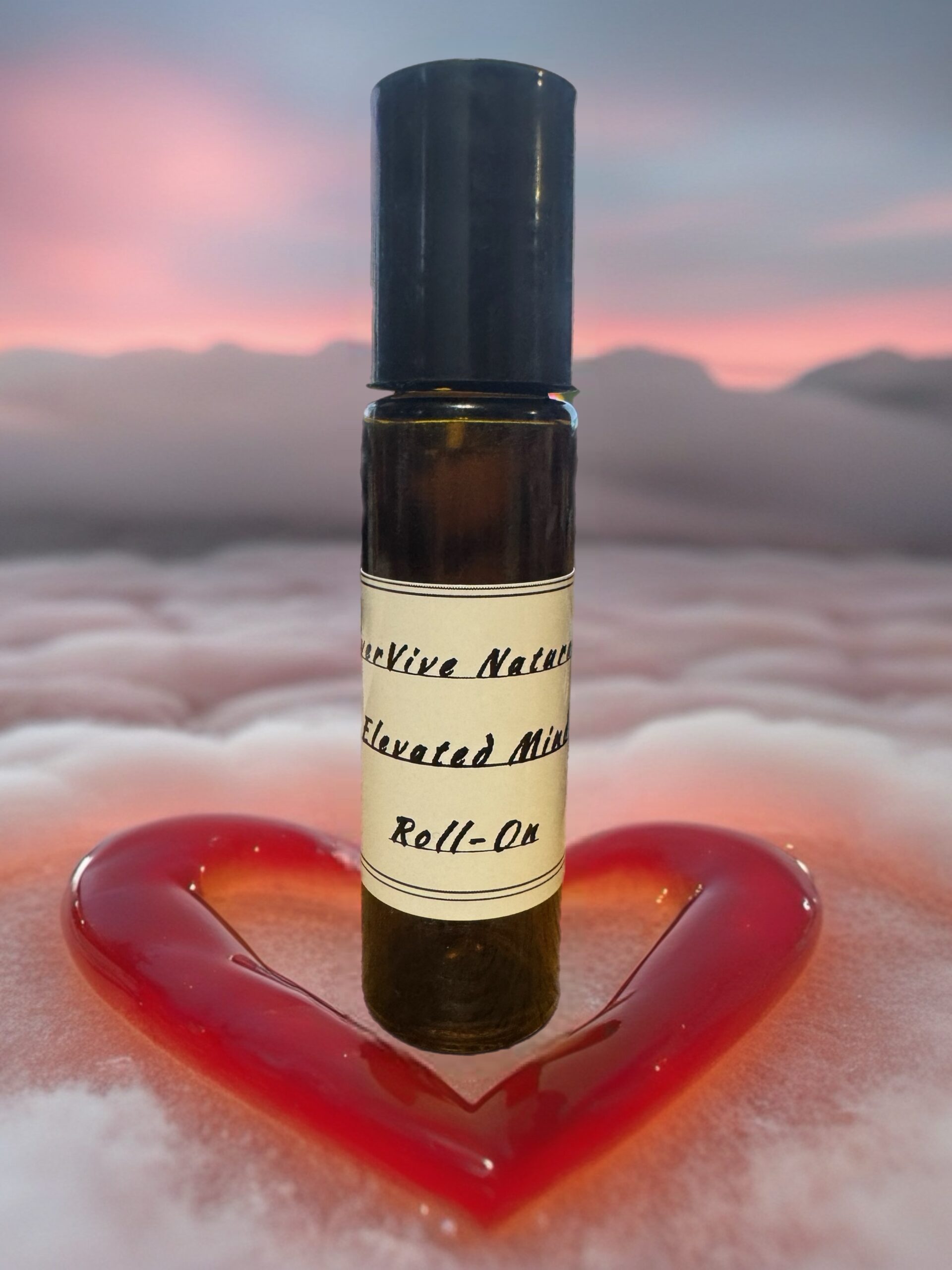 Elevated Mind Roll-On – essential oil roll-on with frankincense, orange, eucalyptus, and cardamom on desk with notebook and pen
