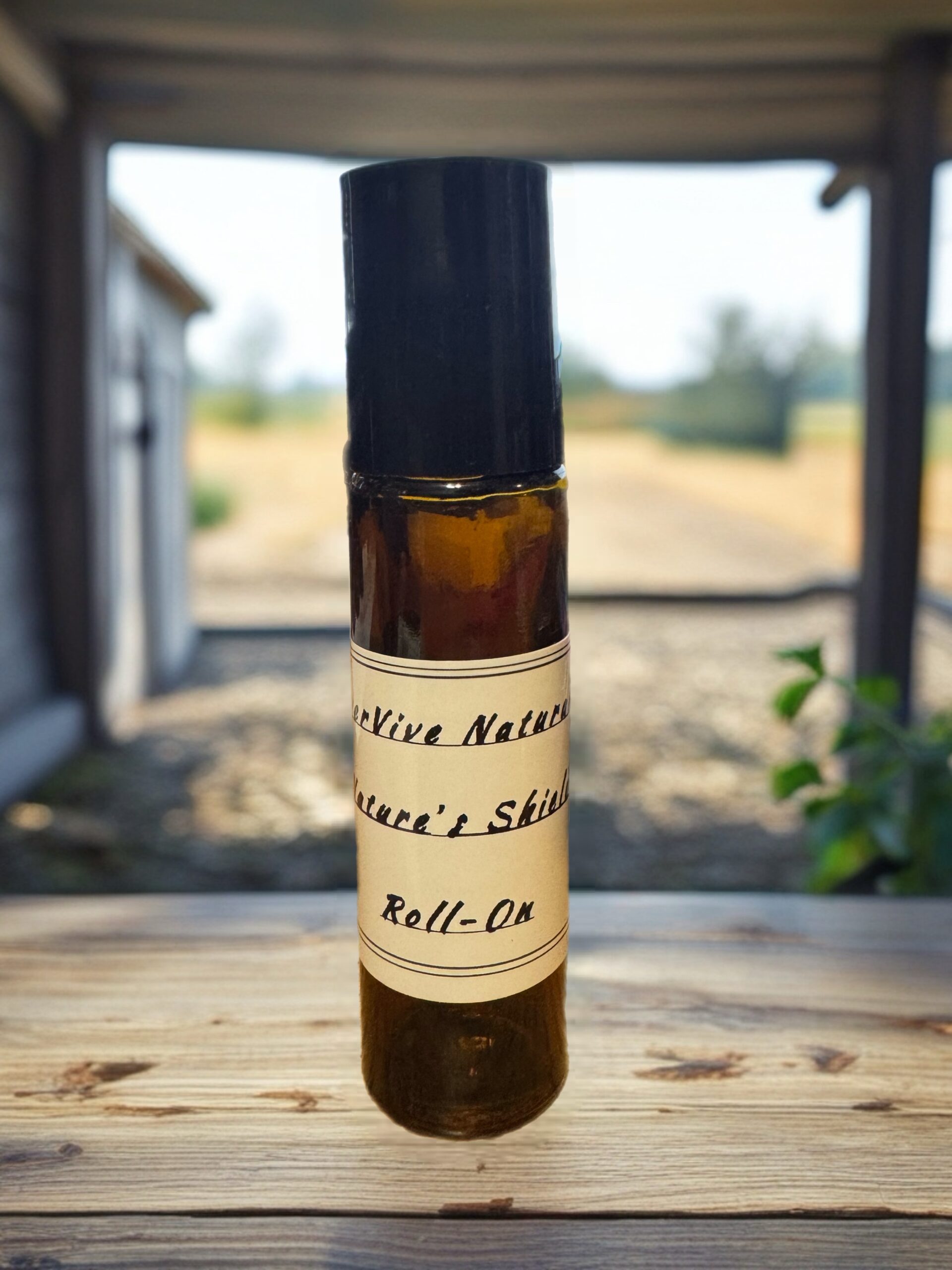Nature’s Shield Roll-On – essential oil bug repellent with grapefruit, patchouli, and lemongrass on wood table with hiking gear and citrus slices